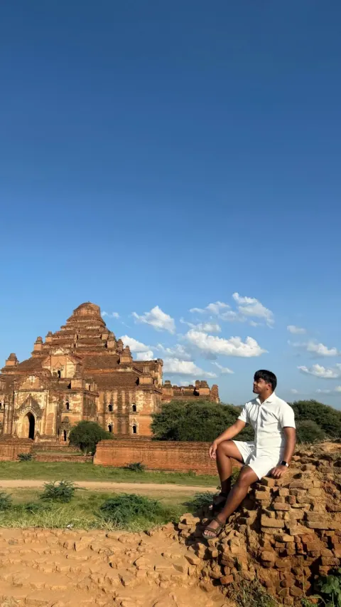Merald sitting on ancient brick ruins in front of a pyramid temple in Bagan, Myanmar