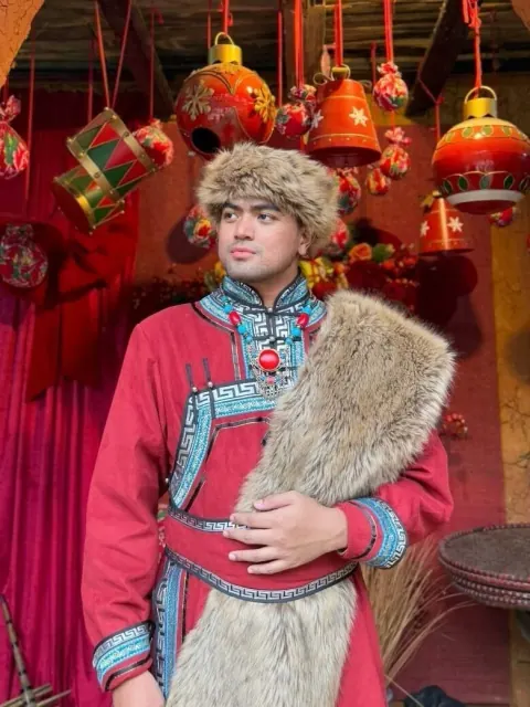 Merald wearing a traditional red Mongolian deel and fur stole